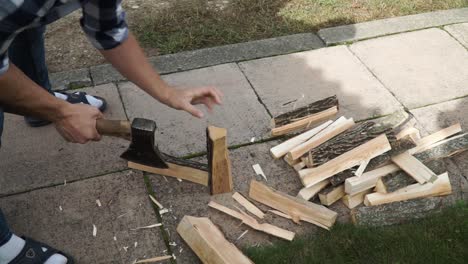 Young man is chopping wood in smaller pieces