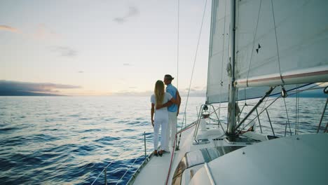 couple sailing on yacht at sunset