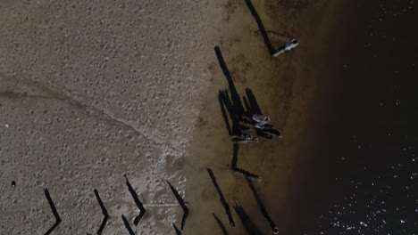 Aerial-birds-eye-view-of-Driftway-in-Scituate,-showing-pilings-and-salt-marsh-on-a-sunny-day