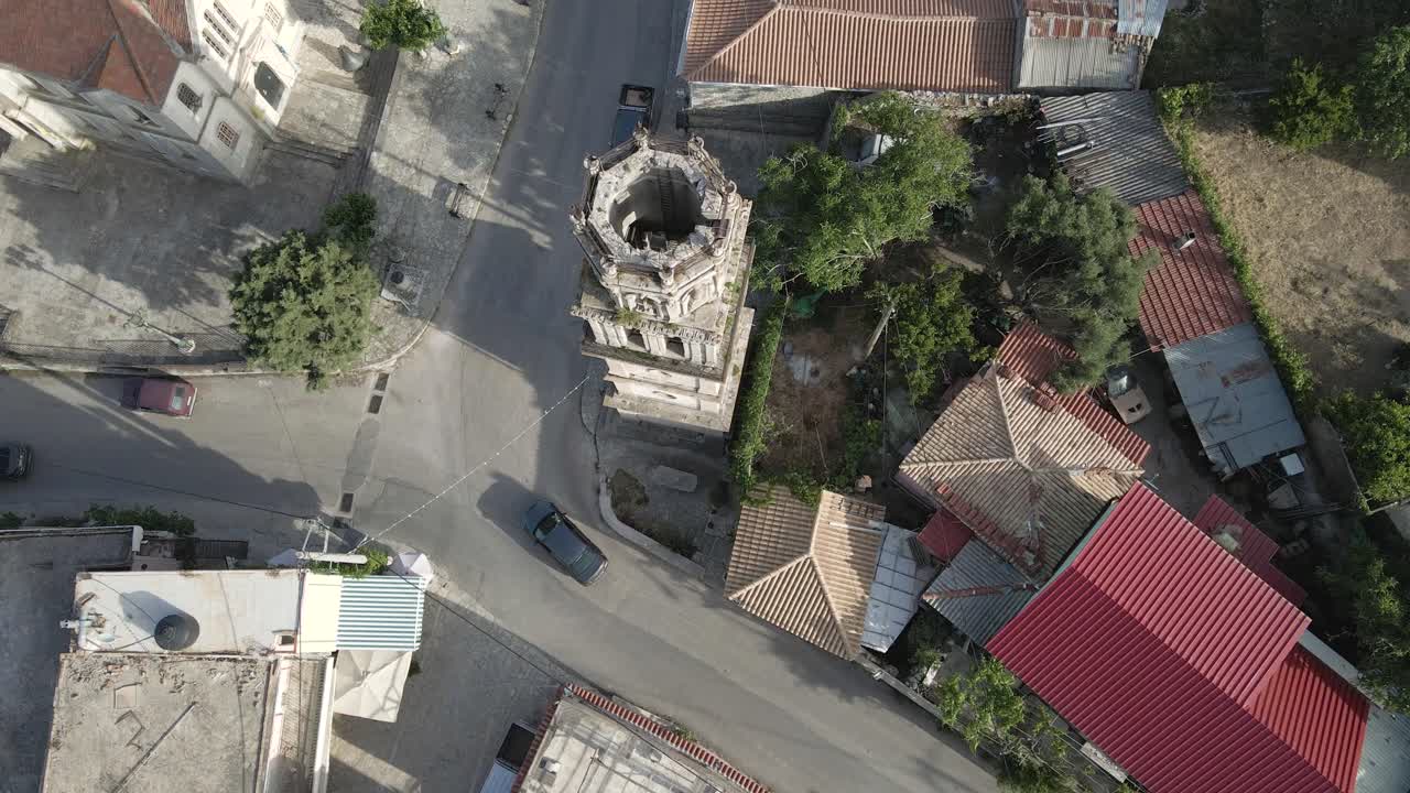 drone panea sobre un pequeño pueblo, rodeando la torre central, en la isla de zakynthos, grecia