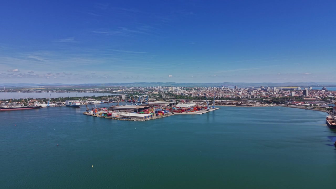 Skyline della città sopra un porto commerciale con gru e acqua in una giornata limpida