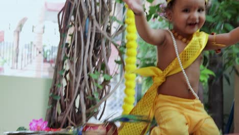 adorable bebé vestido como el dios hindú krishna linda expresión facial con flauta en janmashtami