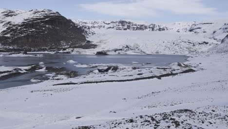 slow dolly overhead a wind marker revealing a frozen lake in the icelandic countryside