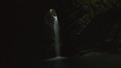 hidden waterfall in a dark canyon