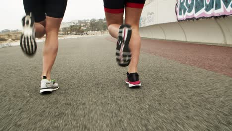 ankles and feet of runners jogging along road