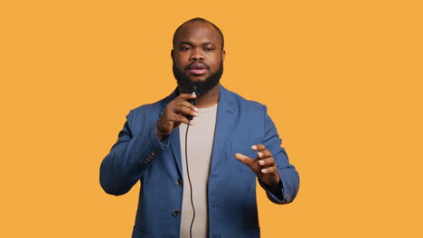 Lecturer-holding-monologue-using-microphone,-studio-background