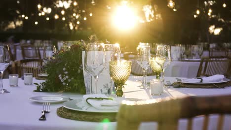 slider shot of restaurant's table set up with wine glasses and white plates in a weeding