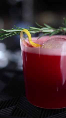 red cocktail with rosemary and lemon