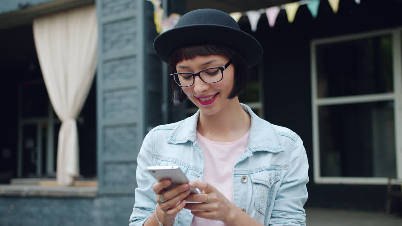 Giovane donna che usa lo smartphone all'aperto