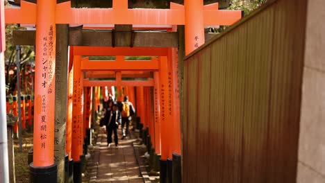 visitors walking under traditional japanese gates