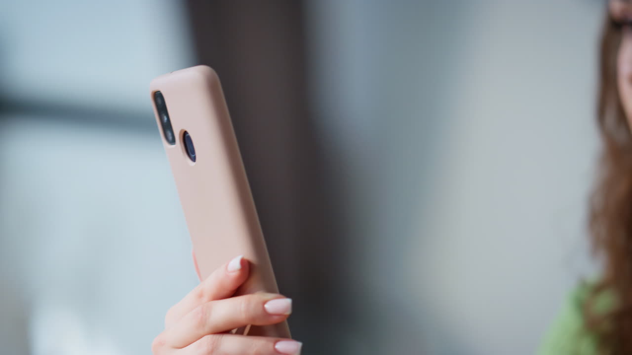 Confident boss watching cellphone at light workplace closeup. Smiling woman