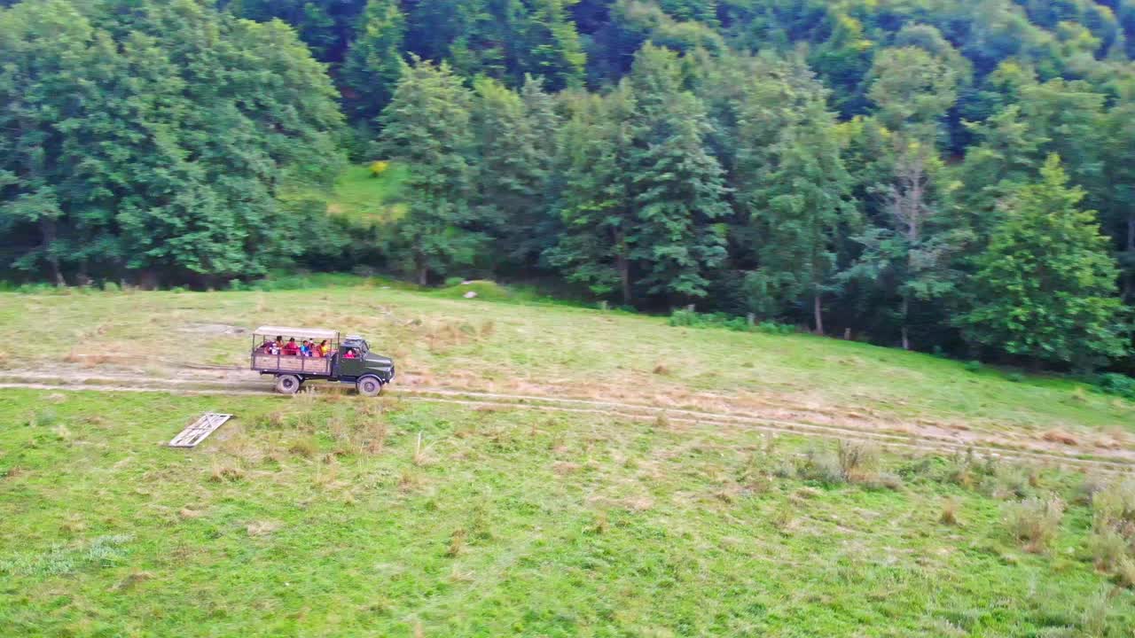 Car with children driving on the highway near the forest in Sovata. Aerial drone shot in the sunset