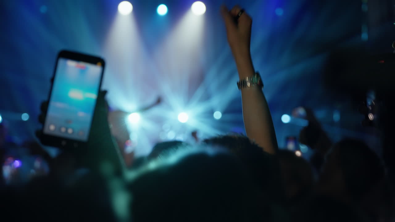 Folla al concerto che registra una performance dal vivo con smartphone e esulta