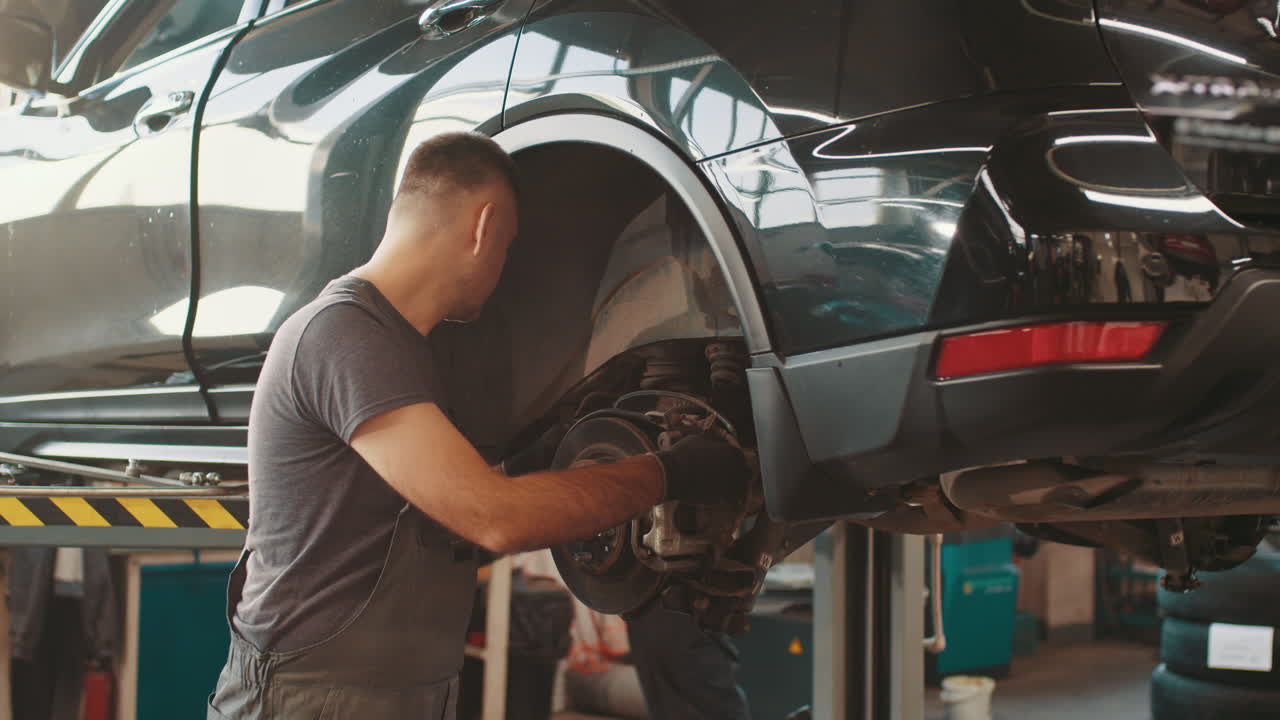 mecánico que repara el sistema de frenos de un automóvil