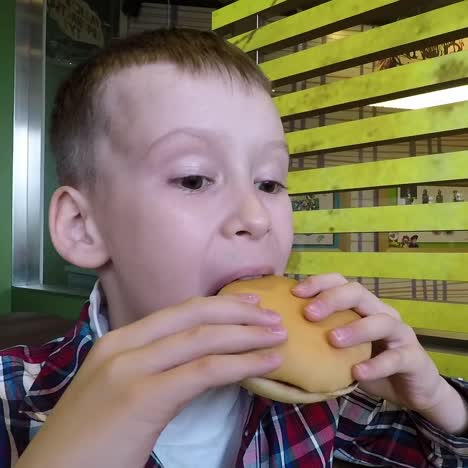 school boy eating hamburger