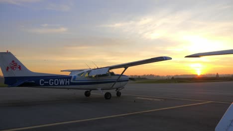 Cessna-Airplane-On-The-Airfield-At-Sunset.-wide