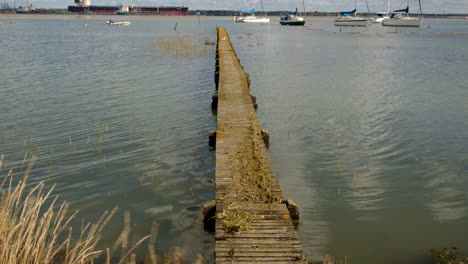 disparo medio de un largo muelle de madera con escombros de inundación en la parte superior