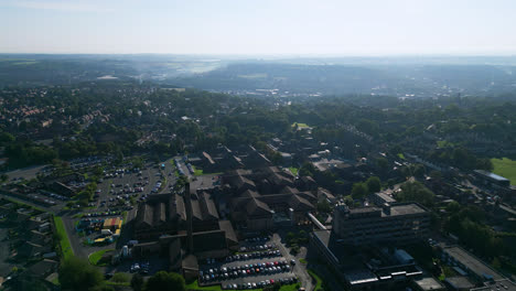 Experience-Staincliff,-UK,-through-drone-shot-aerial-footage,-showcasing-industrial-architecture,-bustling-streets,-Dewsbury-General-Hospital,-and-the-tranquil-Yorkshire-beauty-on-a-summer-morning