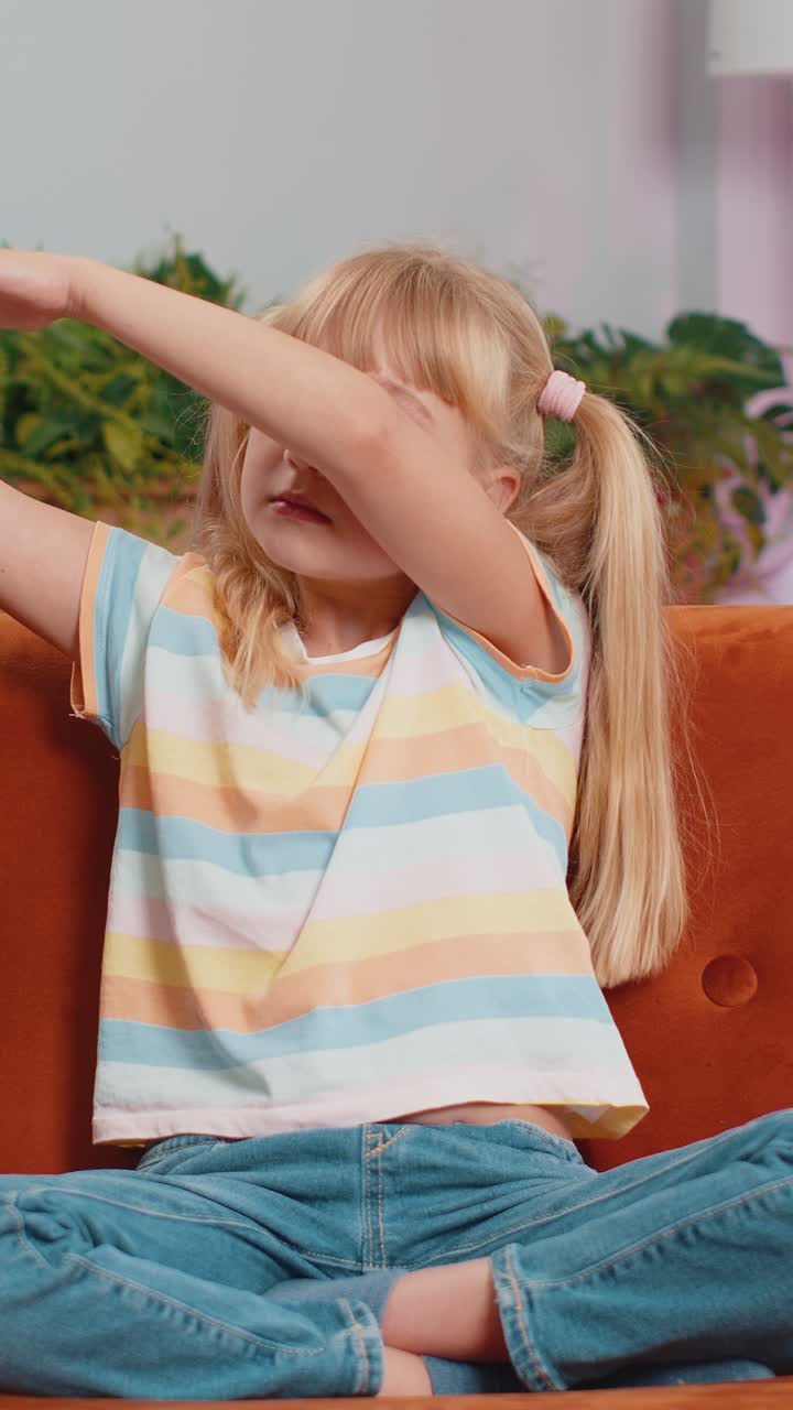 Happy toddler child lady dancing and moving to rhythm making trendy dub dance gesture at modern home