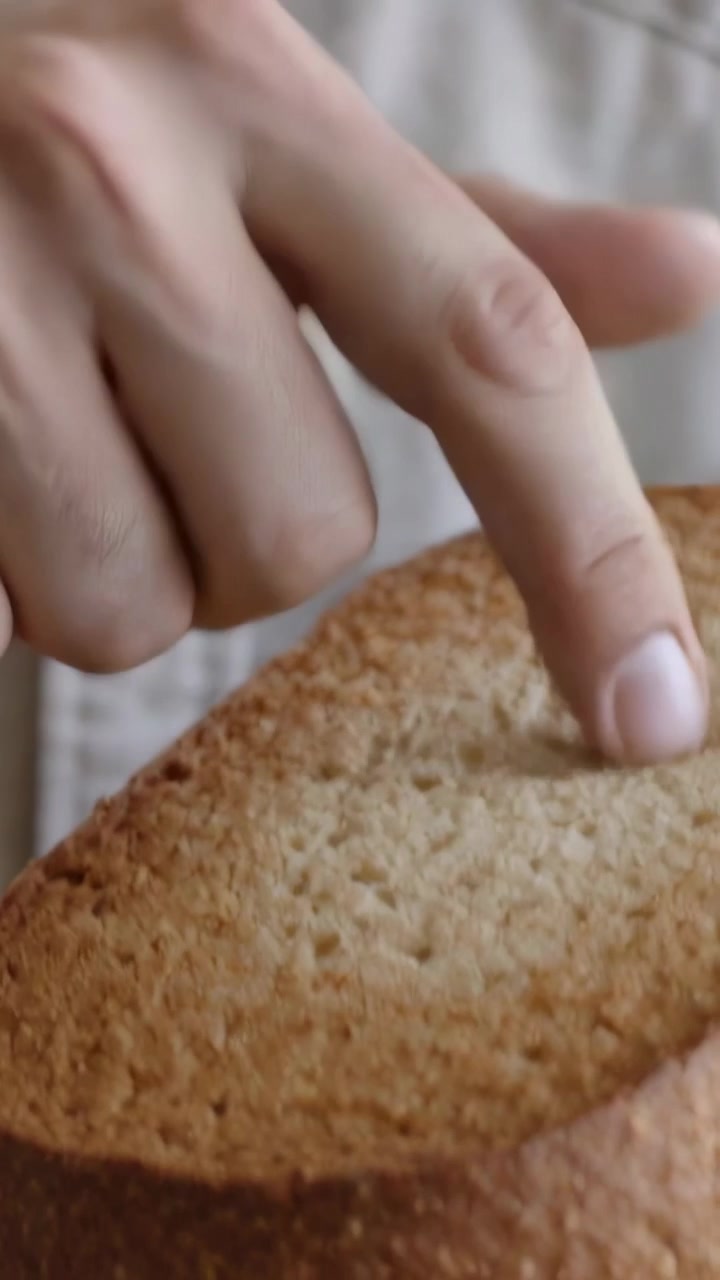 Vertical video: Picking up toast man testing crumb texture with fingers at home, button-up shirt