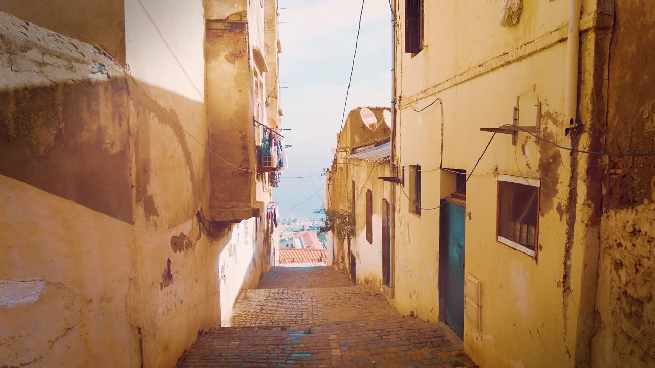알제리의 카스바 지구에 있는 작은 골목으로, 배경에는 지중해를 내려다볼 수 있습니다.