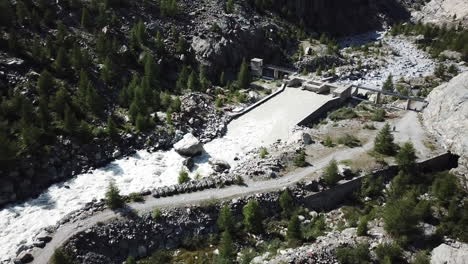 Drone-aerial-view-of-a-mountain-stream-near-fir-forest-in-a-Swiss-alps-valley