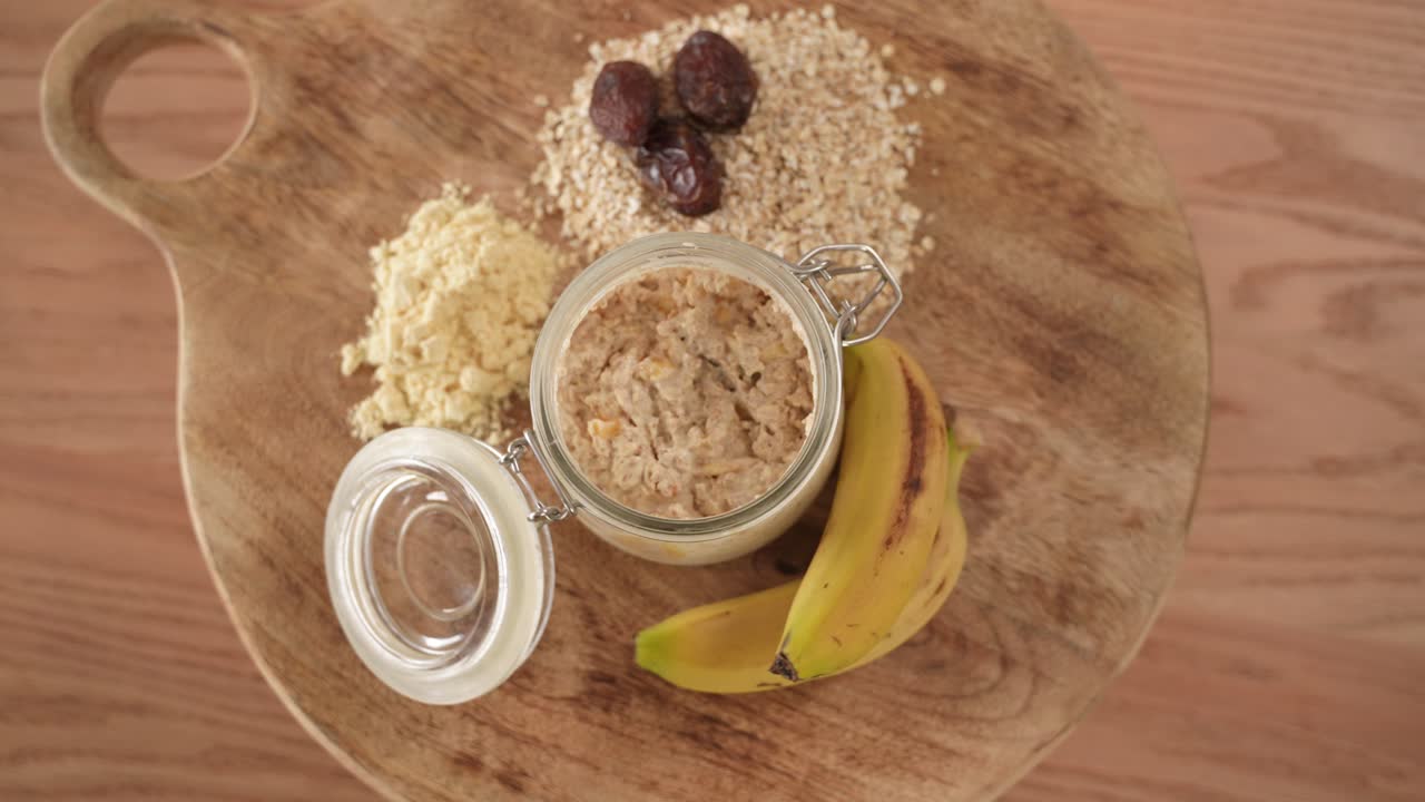 Oatmeal With Dried Dates and Bananas next to it on Wooden Table, Top Down View