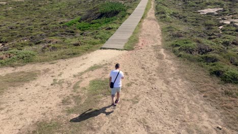 Vista-Aérea-De-Un-Hombre-Caminando-Por-El-Sendero-De-Madera-En-Un-Día-Soleado-De-Verano