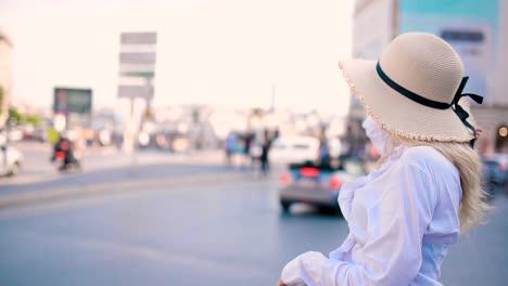 young beautiful girl stands by busy road with traffic on background