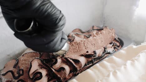 Close-up-of-a-person-scooping-ice-cream-with-a-scoop