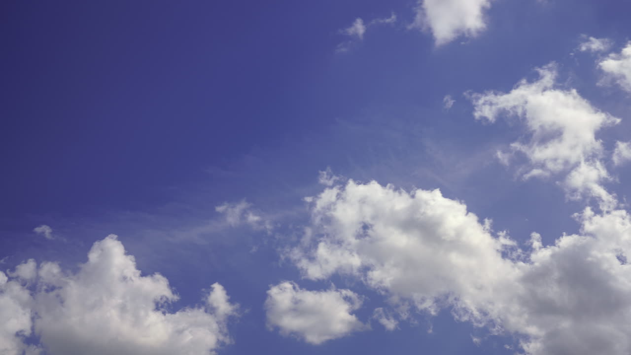 Time-lapse of low clouds in clear bleu sky with light rays, 4K DCI.