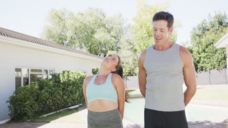 Feliz-Pareja-Caucásica-Haciendo-Yoga-Y-Estirándose-En-Un-Jardín-Soleado,-Cámara-Lenta