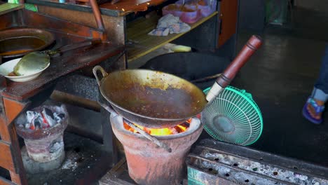 indonesian street food goat fried rice stirred in pan on charcoal fire