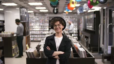 hipster female record shop manager posing and smiling