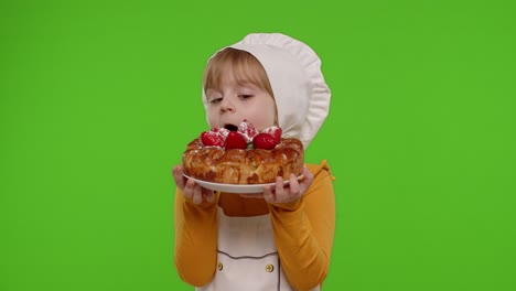 Child-girl-kid-dressed-as-cook-chef-sprinkle-strawberry-cake-with-icing-sugar,-chroma-key-background