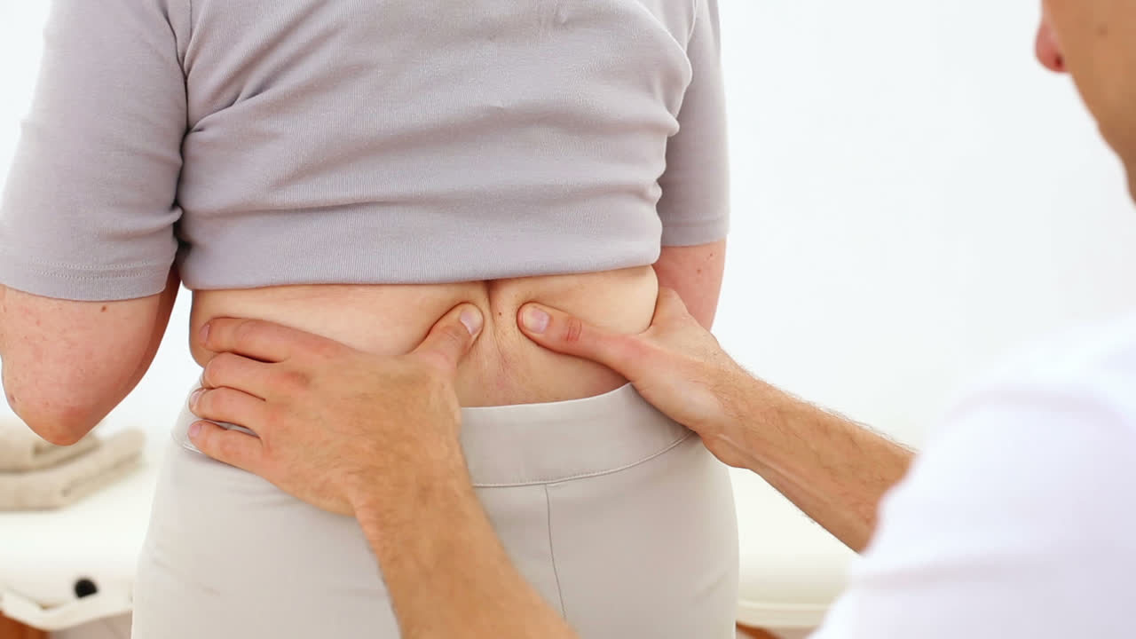 노인 환자 의 등 을 마사지 하는 물리 치료사