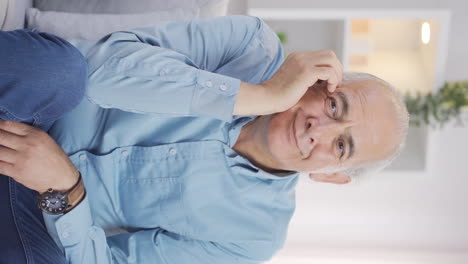 Vertical-video-of-The-old-man-looking-at-the-camera-with-an-idea.