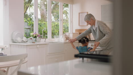 abuela feliz bailando con una niña en la cocina abuela divirtiéndose bailando con su nieta celebrando el fin de semana en casa