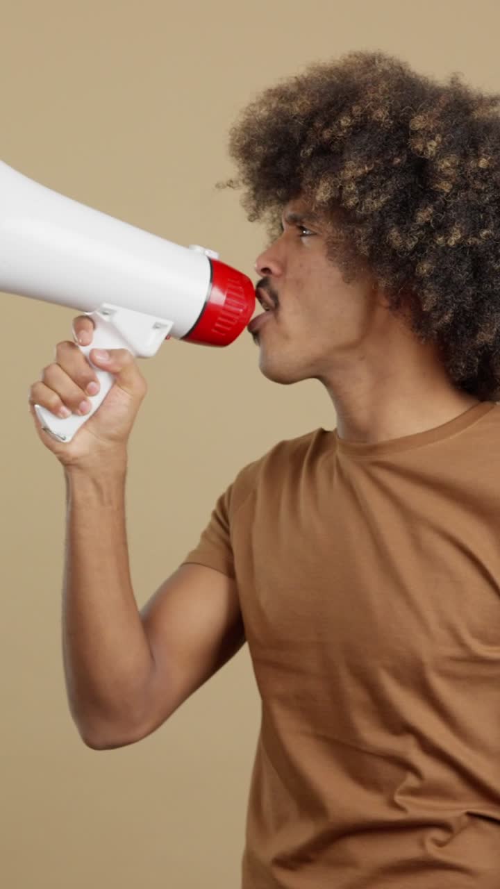 A person with curly hair using a megaphone to communicate or make an announcement