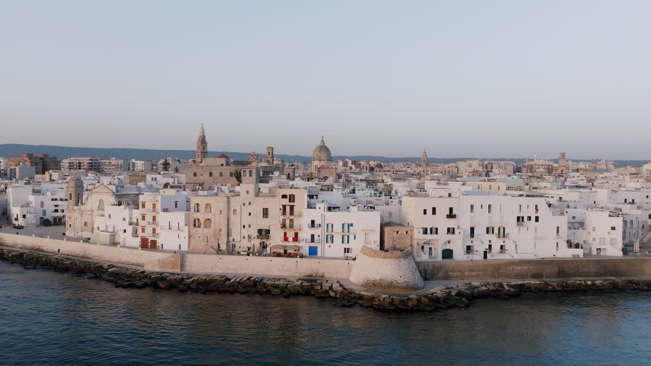 fotografía aérea estática de la ciudad costera de monopoli, italia con las olas tranquilas del mar mediterráneo arrastrándose contra la pared de la ciudad