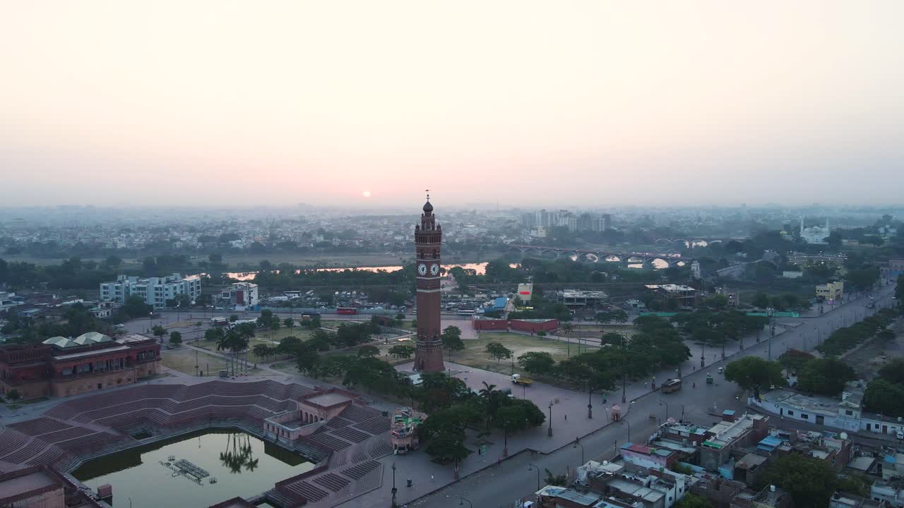 una toma de avión no tripulado de la torre del reloj de lucknow al amanecer, destacando su arquitectura icónica contra un cielo colorido.