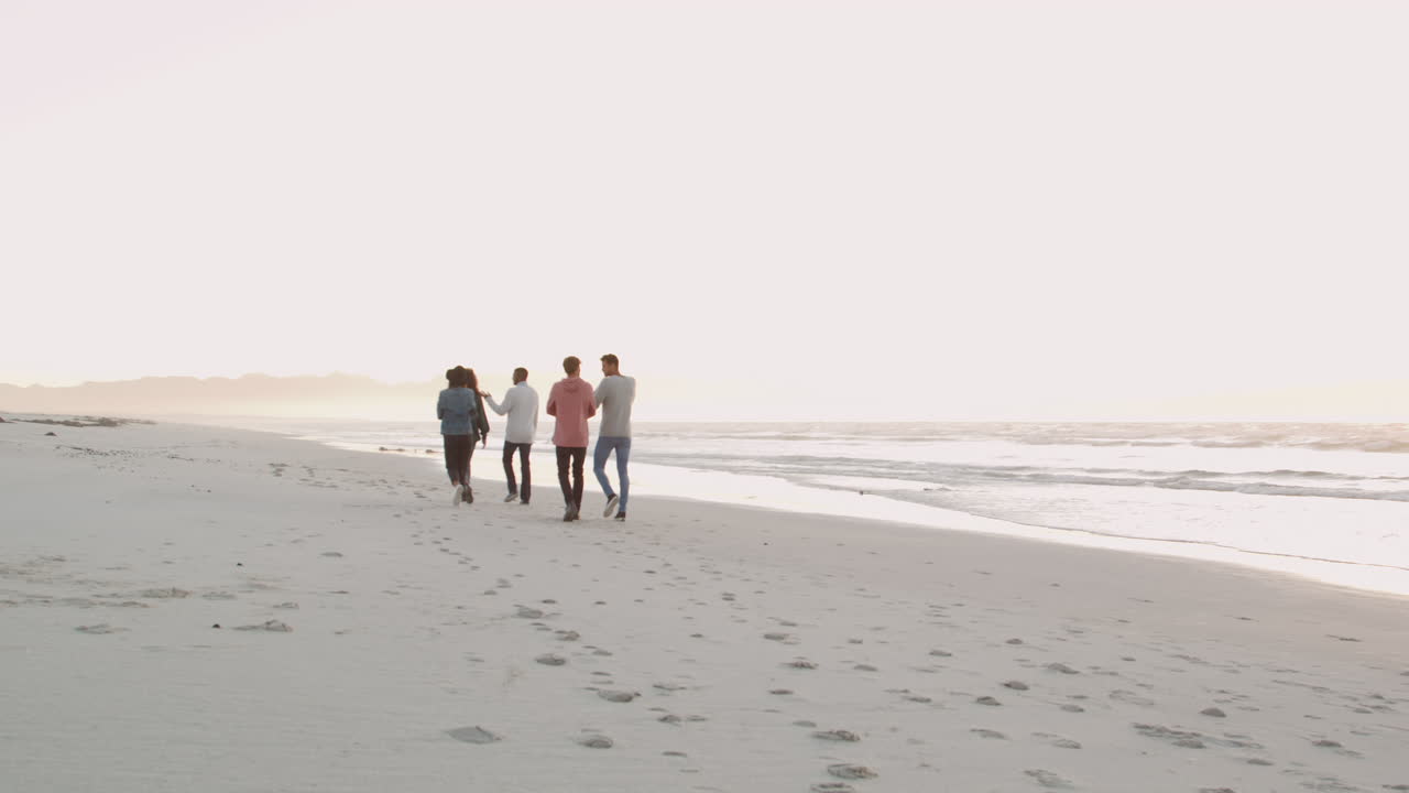 친구 들 이 함께 겨울 해변 을 따라 고 있는 뒤면