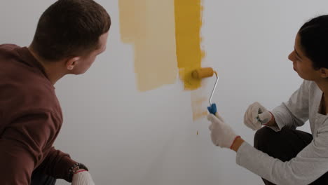 pareja pintando una pared juntos