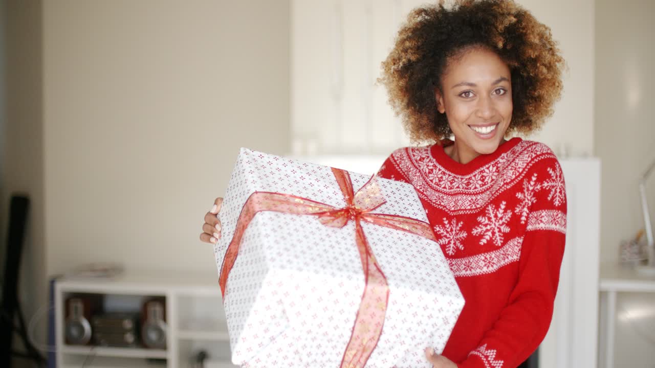 una hermosa chica sorprendida de pie con una caja grande