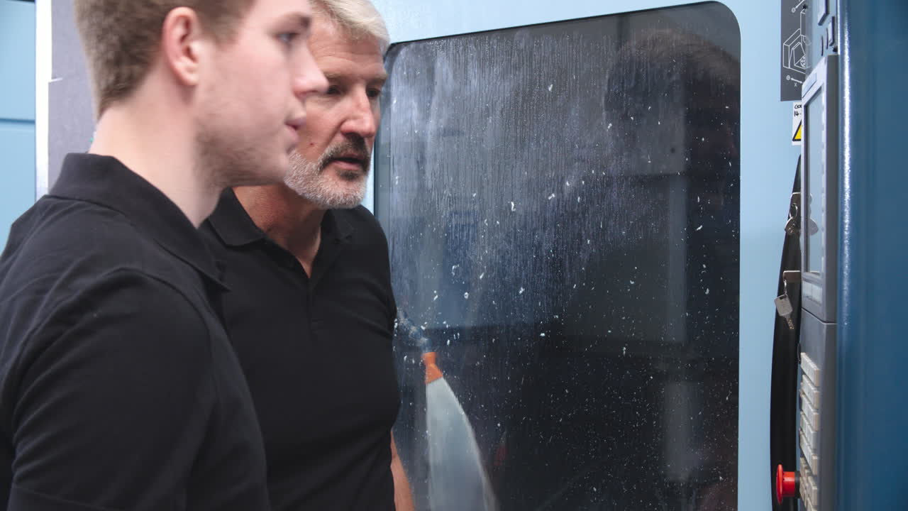 cnc 기계에서 엔지니어와 함께 일하는 남성 견습생