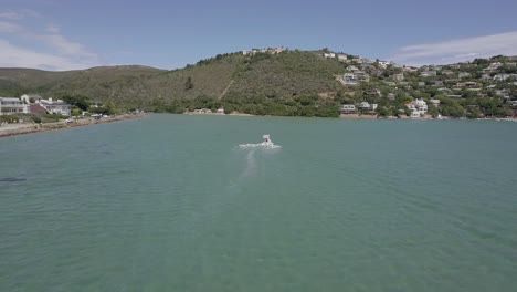 following aerial of inflatable boat with sun shade in shallow lagoon