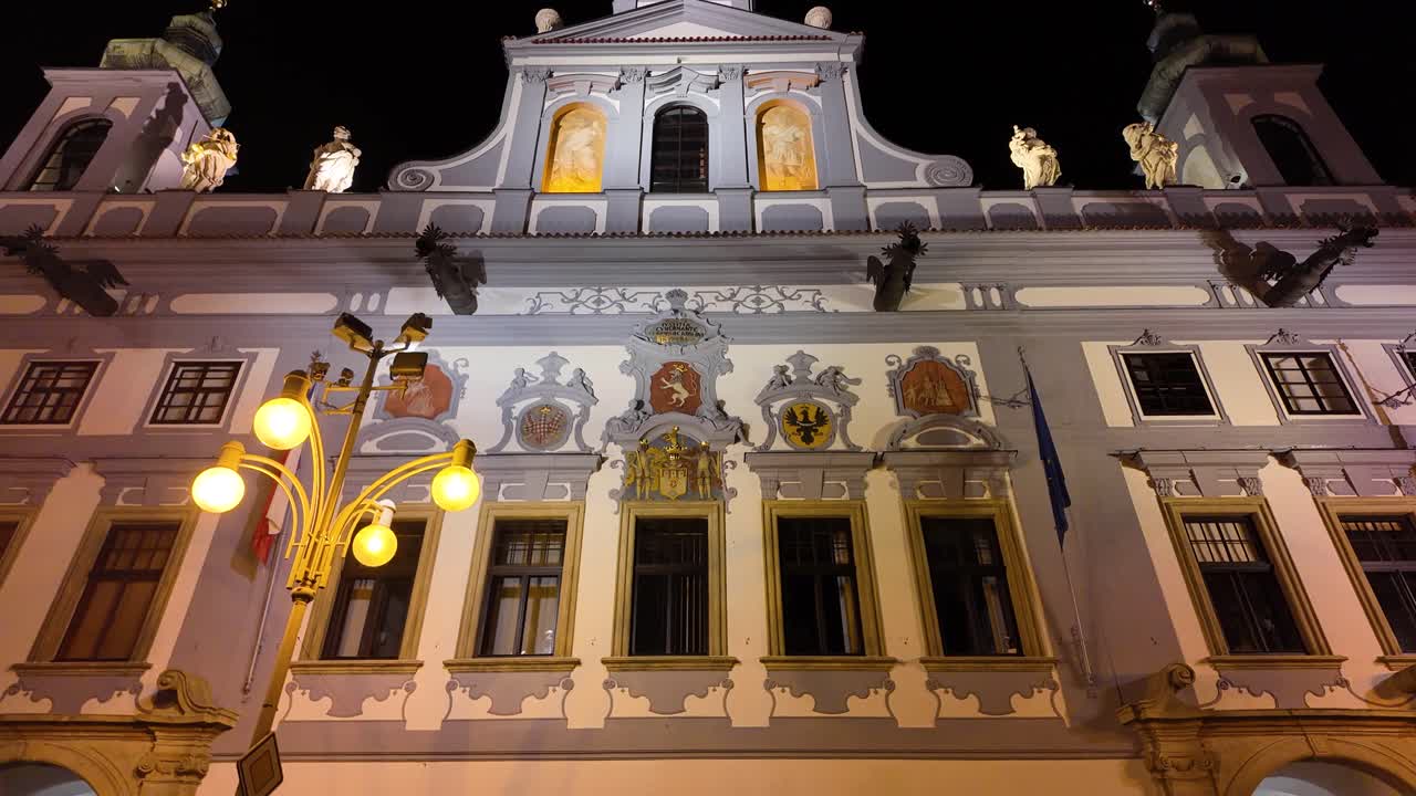 Illuminated town hall building at Přemysla Otakara II Square in České Budějovice, Czech Republic, captured at night.