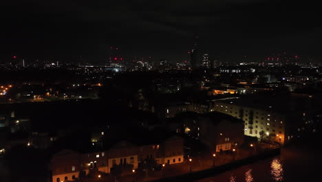 aerial tracking shot in front of the rotherhithe neighborhood, night in london
