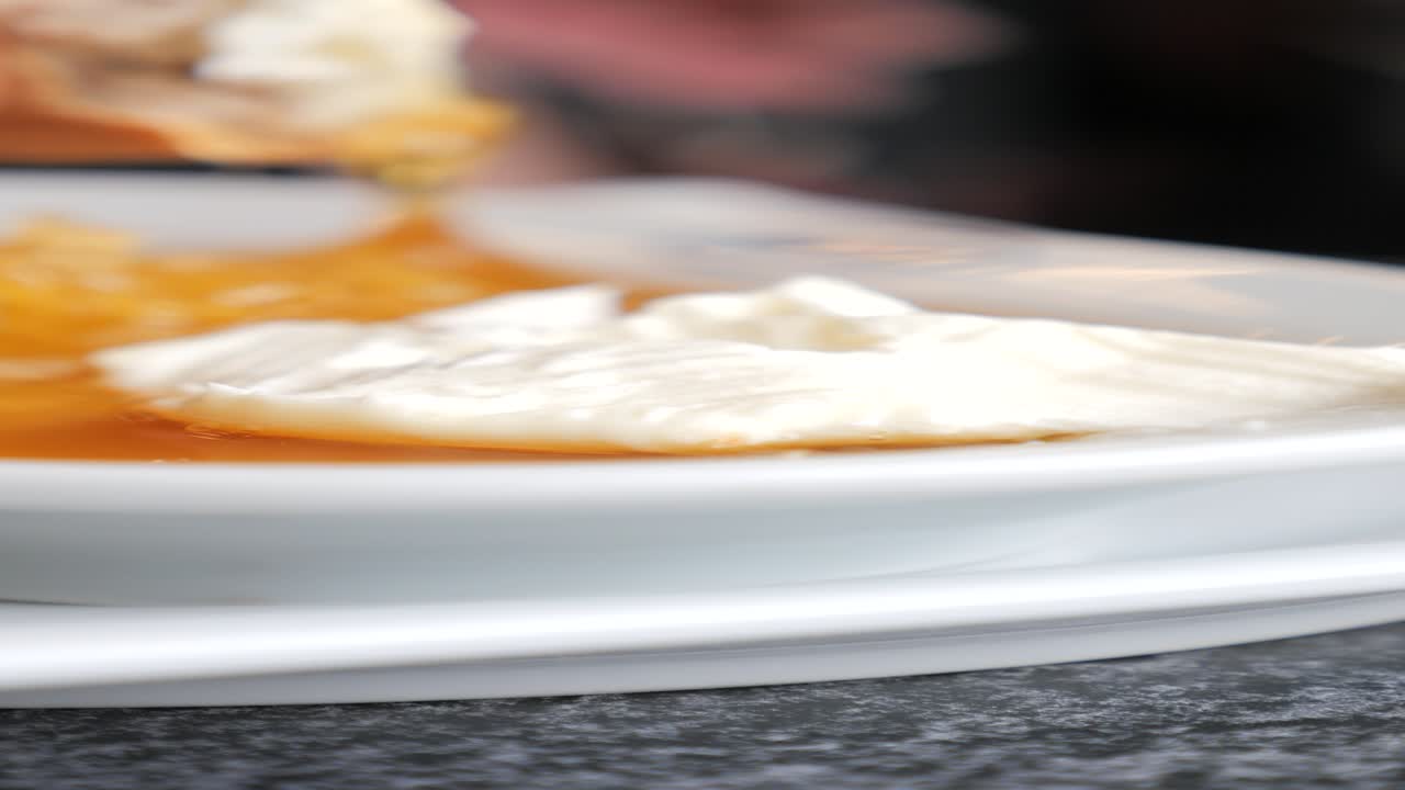 un primer plano de un plato de yogur con miel y pan