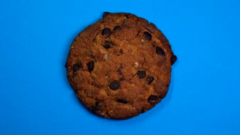 una galleta de chocolate en primer plano, una foto macro, girando lentamente sobre un fondo azul giratorio.